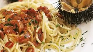 Spaghetti ai Ricci di Mare - Spaghetti artigianali mantecati con polpa fresca di ricci di mare della costa siciliana, olio extravergine d'oliva DOP Nocellara del Belice e prezzemolo fresco. Un piatto che racchiude i sapori autentici del Mar Mediterraneo.